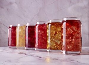 row of jars filled with different colored liquid representing various beverages in the manufacturing process