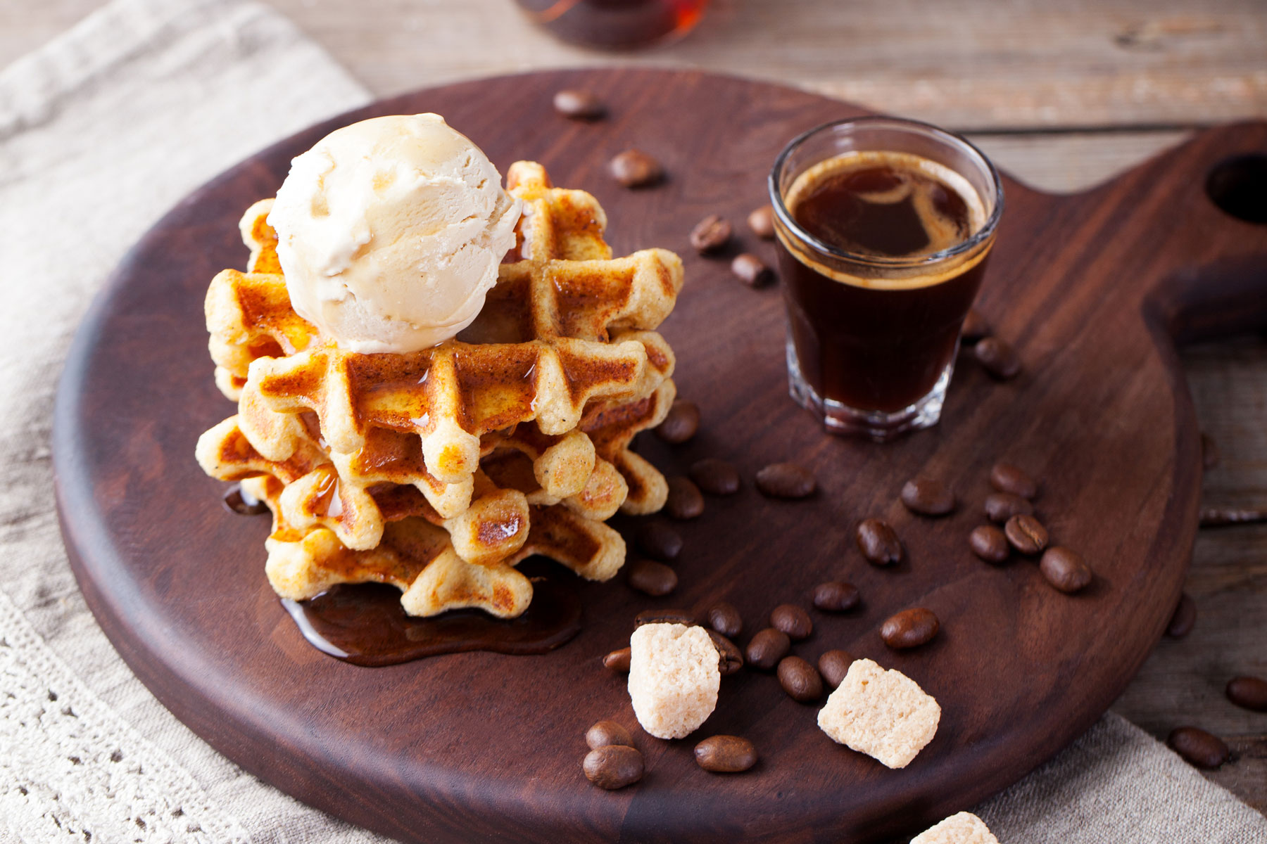 A plate of waffles with ice cream and coffee