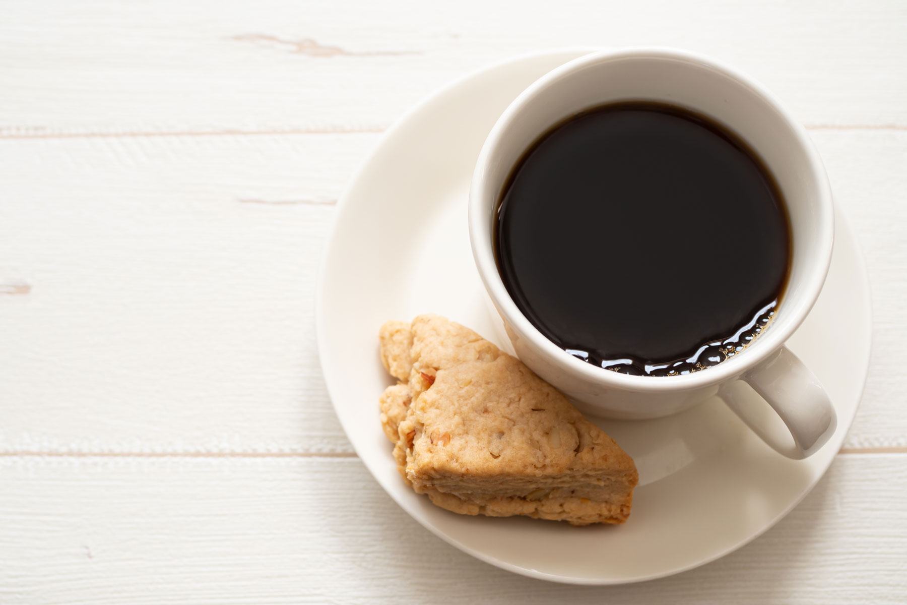 a cup of coffee and a biscuit on a saucer