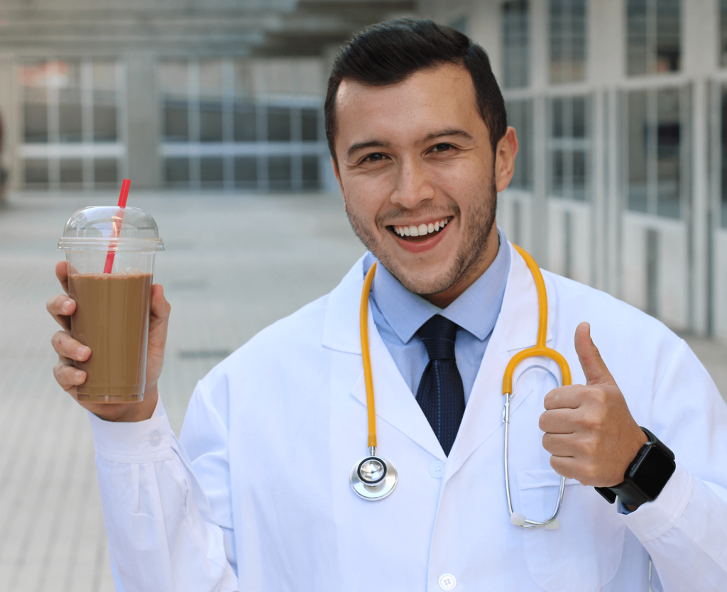 A man in a white lab coat holding a cup of coffee