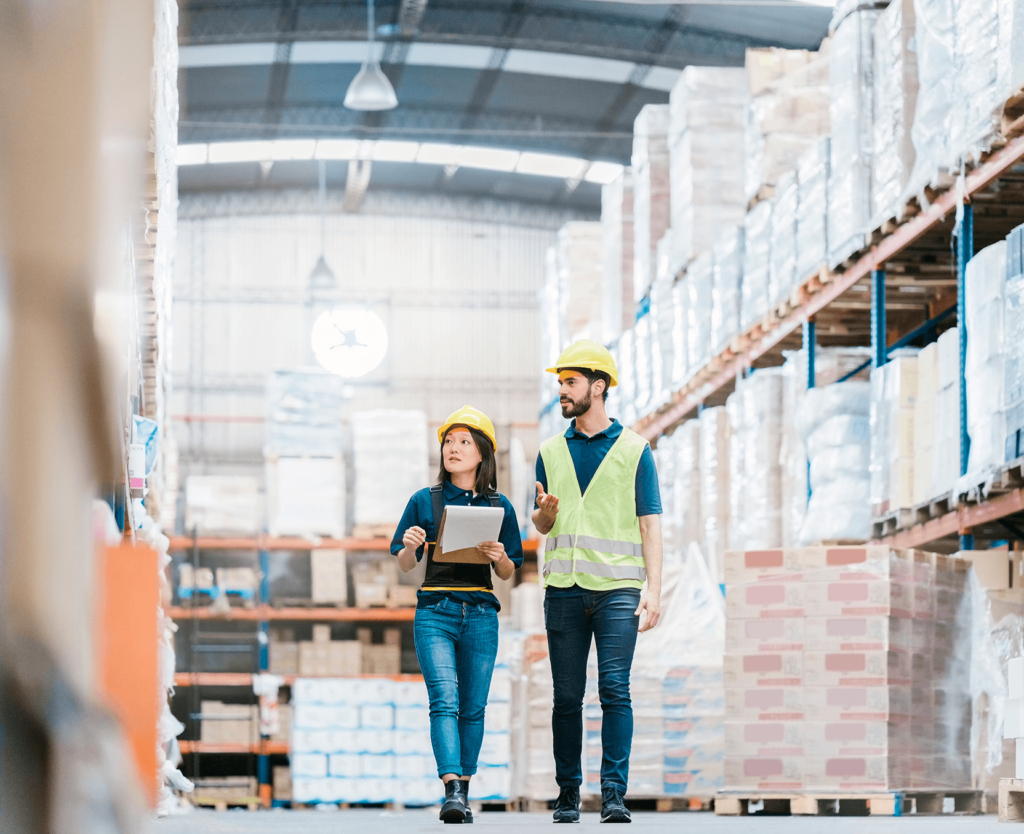 a man and a woman walking through a warehouse