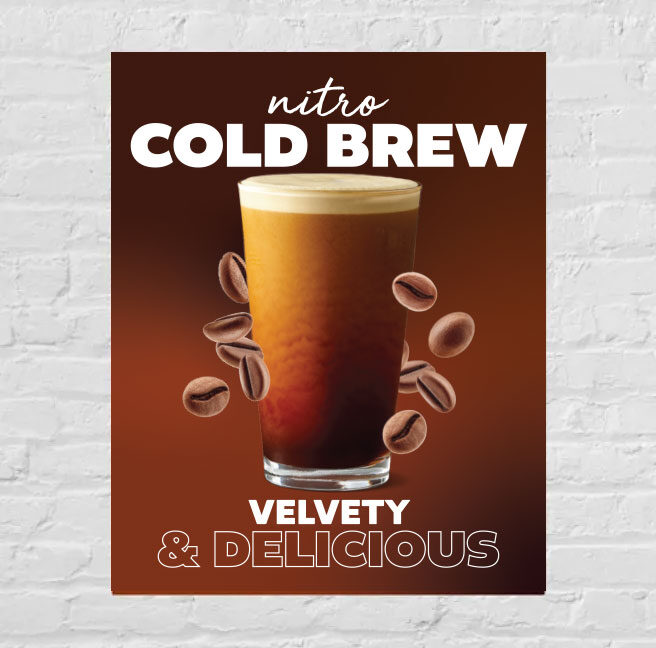 poster on a brick wall advertising a cold beverage